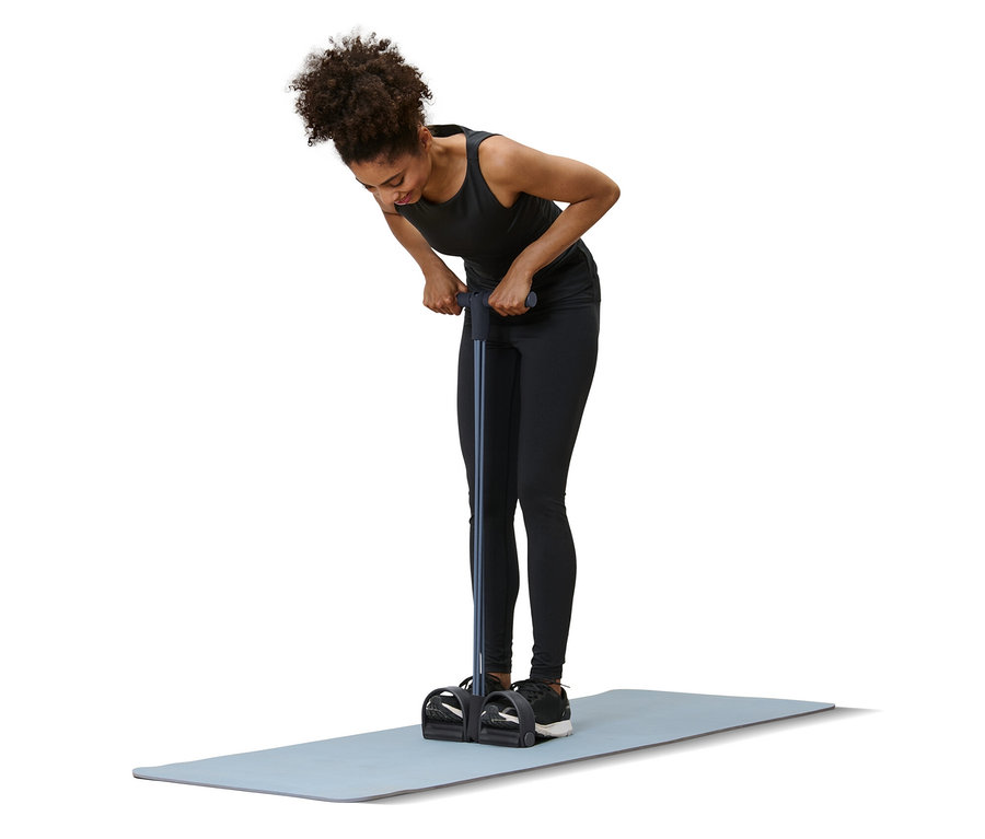 Femme faisant de l’exercice avec un accessoire d’entraînement pour les abdos et le dos sur un tapis.