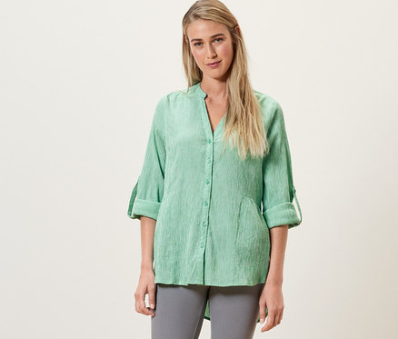 Femme portant une tunique longue rayée verte.