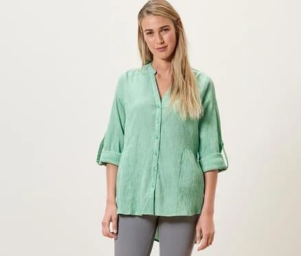 Femme portant une tunique longue rayée verte.