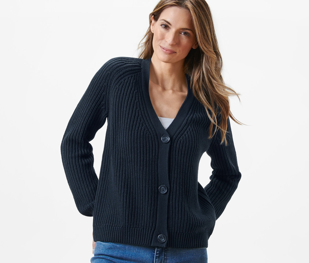 Femme portant un cardigan bleu marine en grosse maille et un jean.