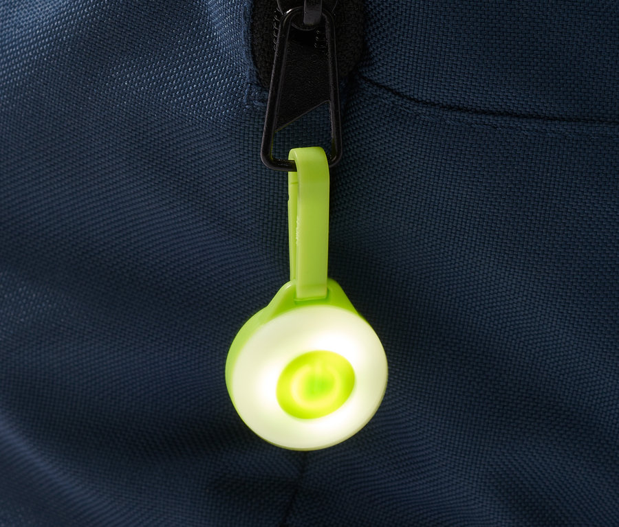 Un pendentif LED vert, lot de 3, est accroché à la fermeture éclair d'un sac bleu.