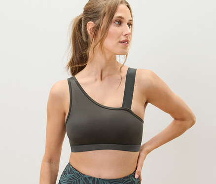 Femme posant en brassière de sport et leggings à motifs de feuilles.