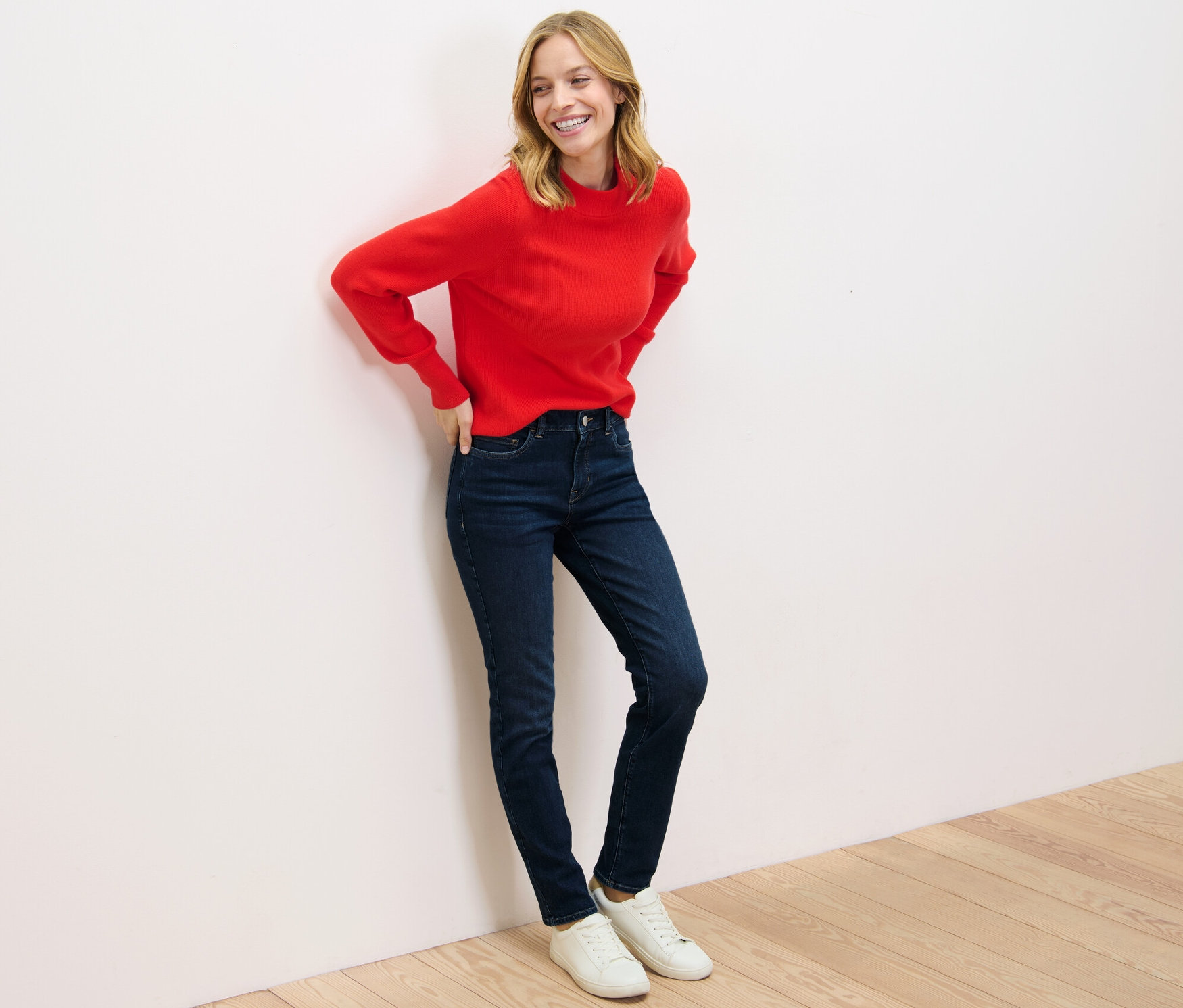 Femme posant en pull rouge et jean slim – Fit « Emma ».