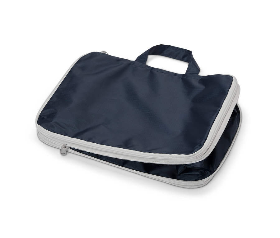 Un sac de compression bleu marine avec une fermeture éclair argentée et une poignée.