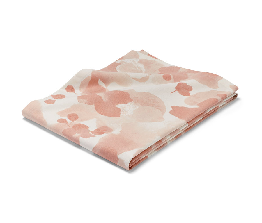 Nappe pliée, env. 140 x 180 cm, avec un motif floral abstrait dans les tons rose et blanc.
