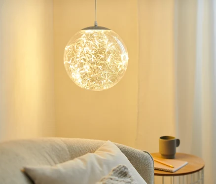 Une boule LED d'environ 30 cm suspendue illumine un salon.