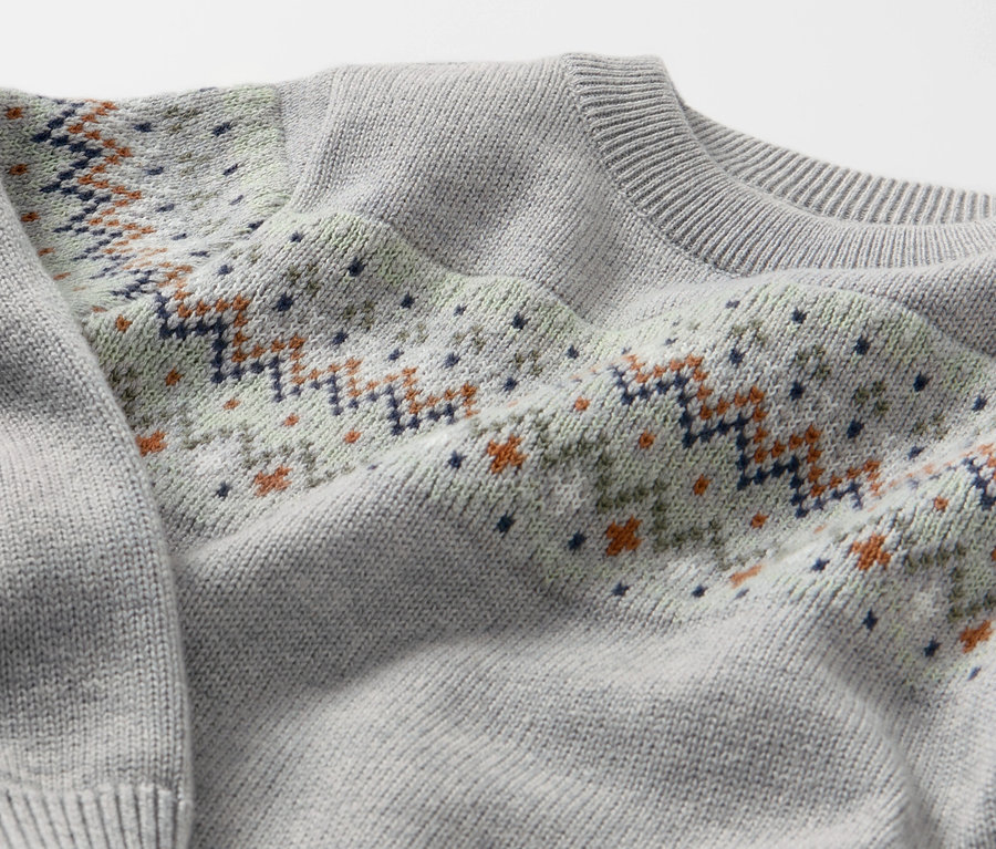 Gros plan sur un pull en maille pour enfant avec motif.