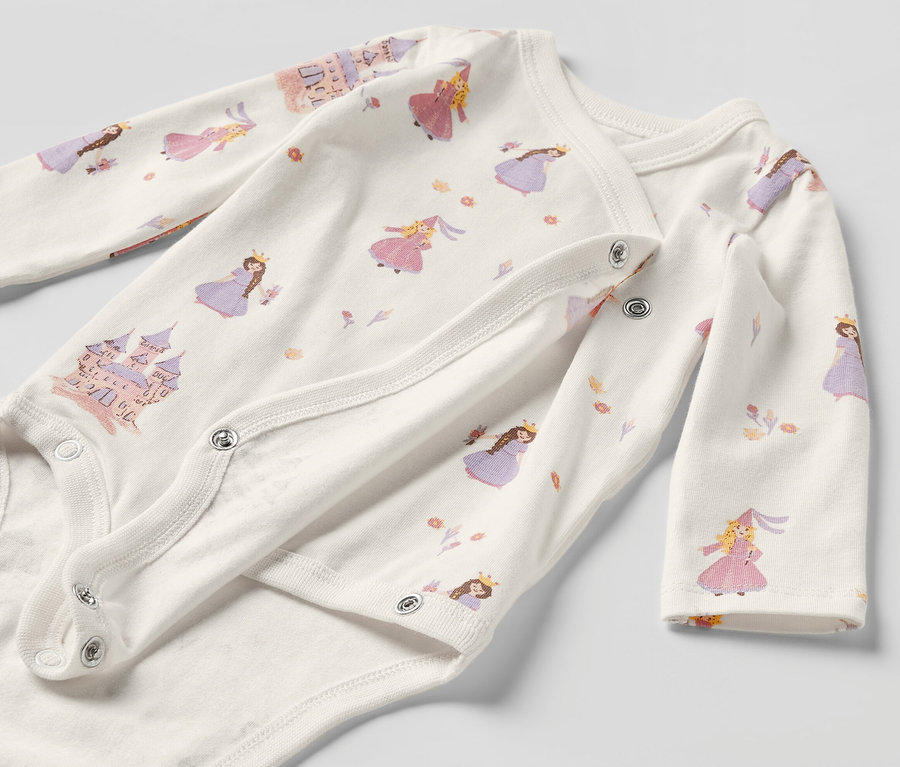 Gros plan sur un body évolutif pour bébé avec un motif de princesses.