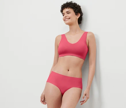 Femme posant en culotte et brassière rouge corail, 2 culottes Magic Cut.
