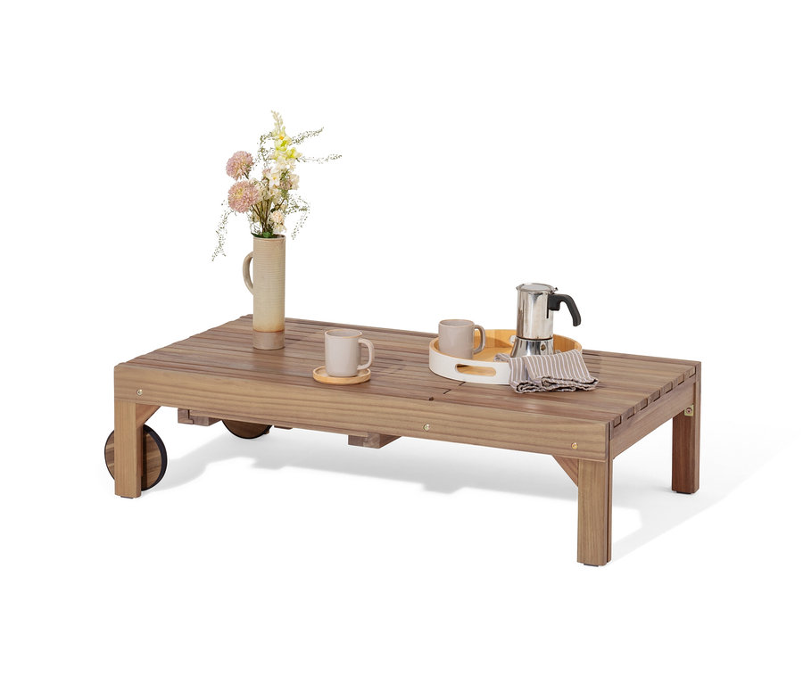 Sur une table en bois se trouvent un vase de fleurs, deux tasses et une cafetière. La liste de produits contient 'Chaise longue extensible « Tinus » avec matelas de qualité supérieure', mais le produit n'est pas visible sur l'image.