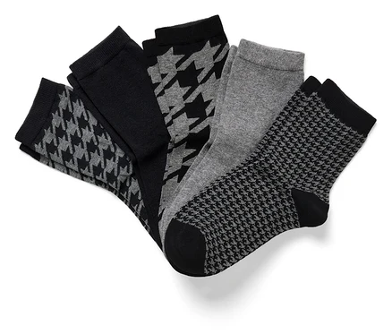Cinq paires de chaussettes : une noire unie, deux à motif pied-de-poule et une grise unie.