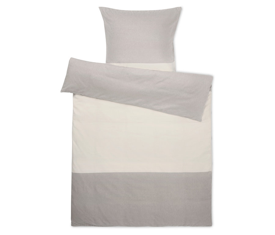 Ensemble de literie avec taie d'oreiller et housse de couette grises sur fond blanc.