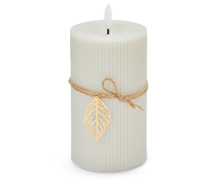 Une bougie blanche avec une ficelle et une feuille d'or sur fond blanc.