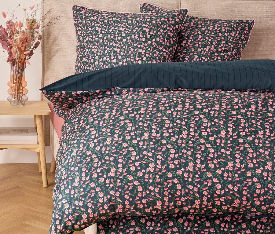 Linge de lit fleuri avec oreillers sur un lit.