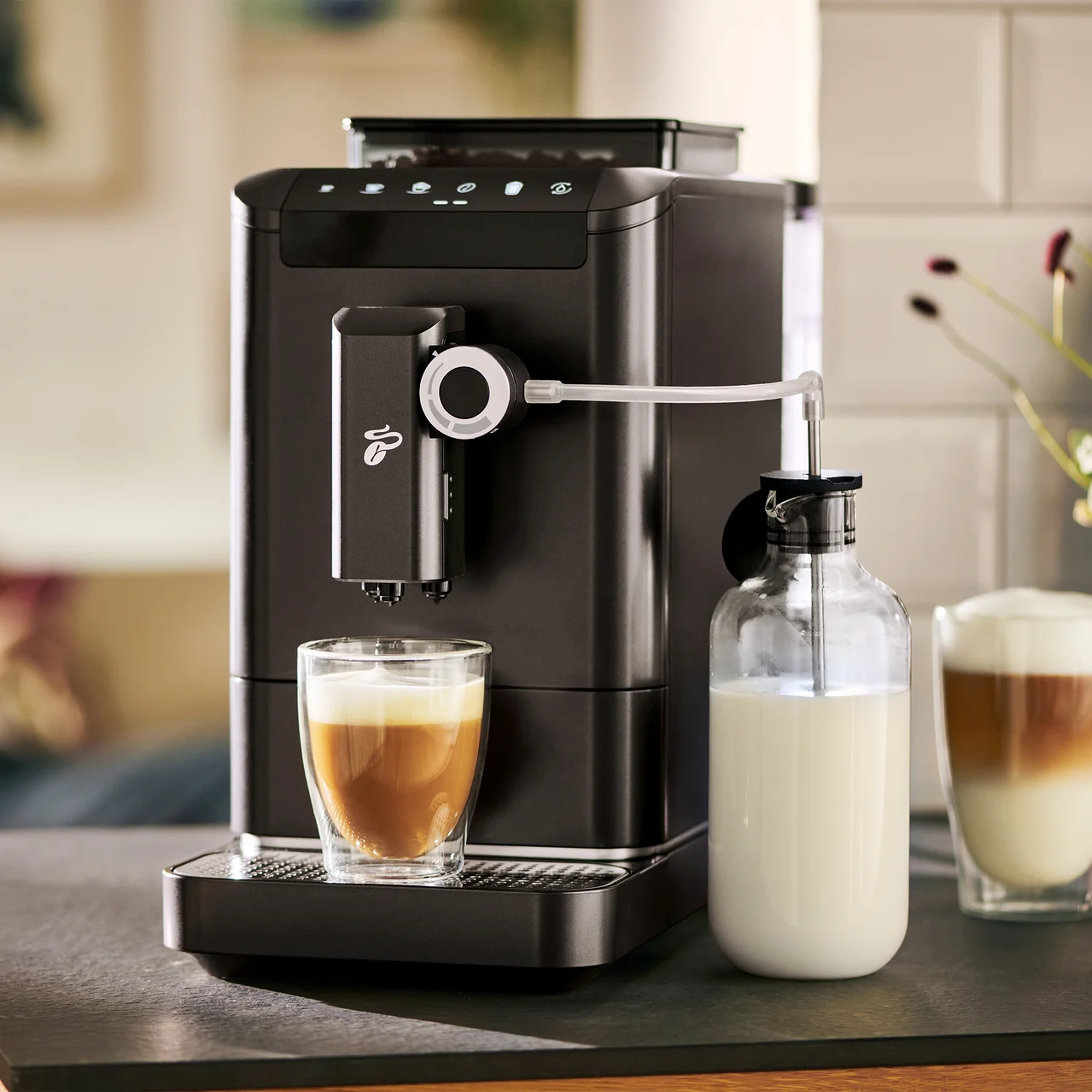 Une machine à café automatique prépare du café dans un verre à côté d'une bouteille de lait.