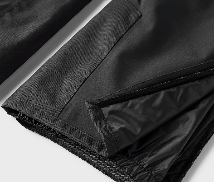 Détail d'un pantalon noir avec fermeture éclair ouverte.