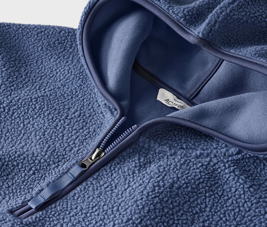 Gros plan d'un sweat-shirt en polaire bleu avec capuche et fermeture éclair.