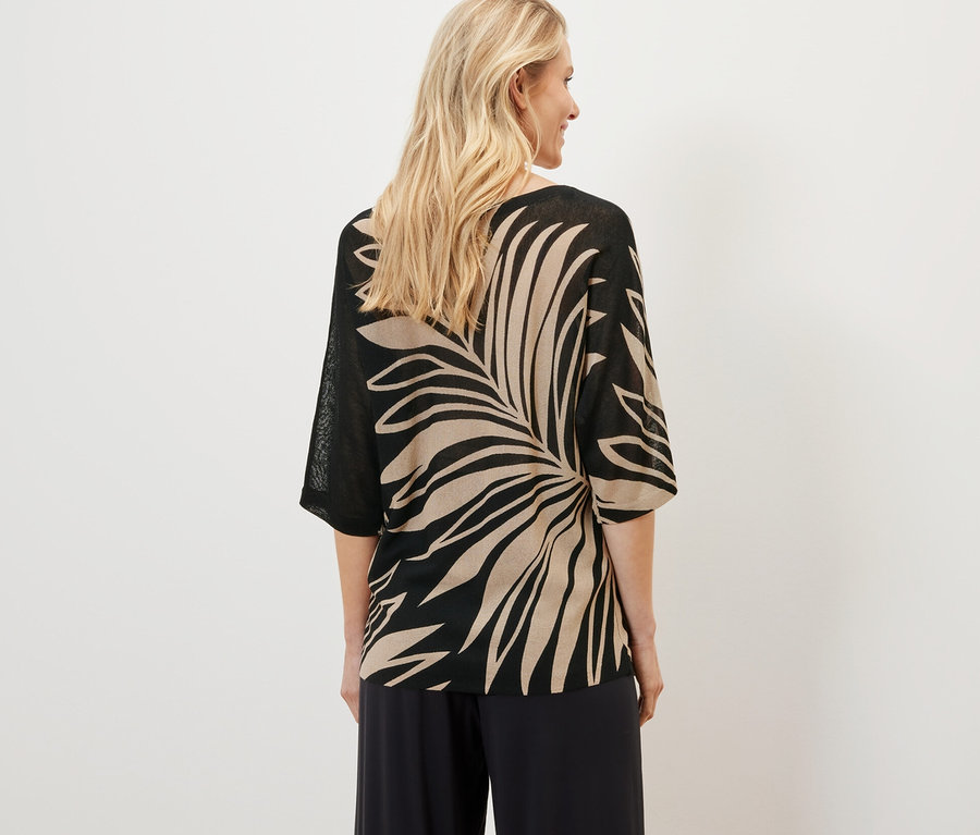 Femme portant un pull-over en maille fine imprimé.