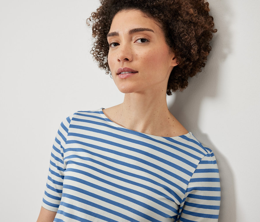 Femme portant un t-shirt bleu à rayures à manches trois-quarts.