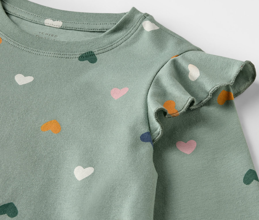Gros plan sur une chemise de nuit pour enfants avec un motif de coeurs.
