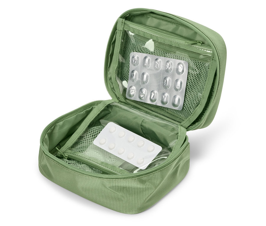 Trousse de premiers secours verte ouverte avec des plaquettes alvéolées de médicaments à l'intérieur.