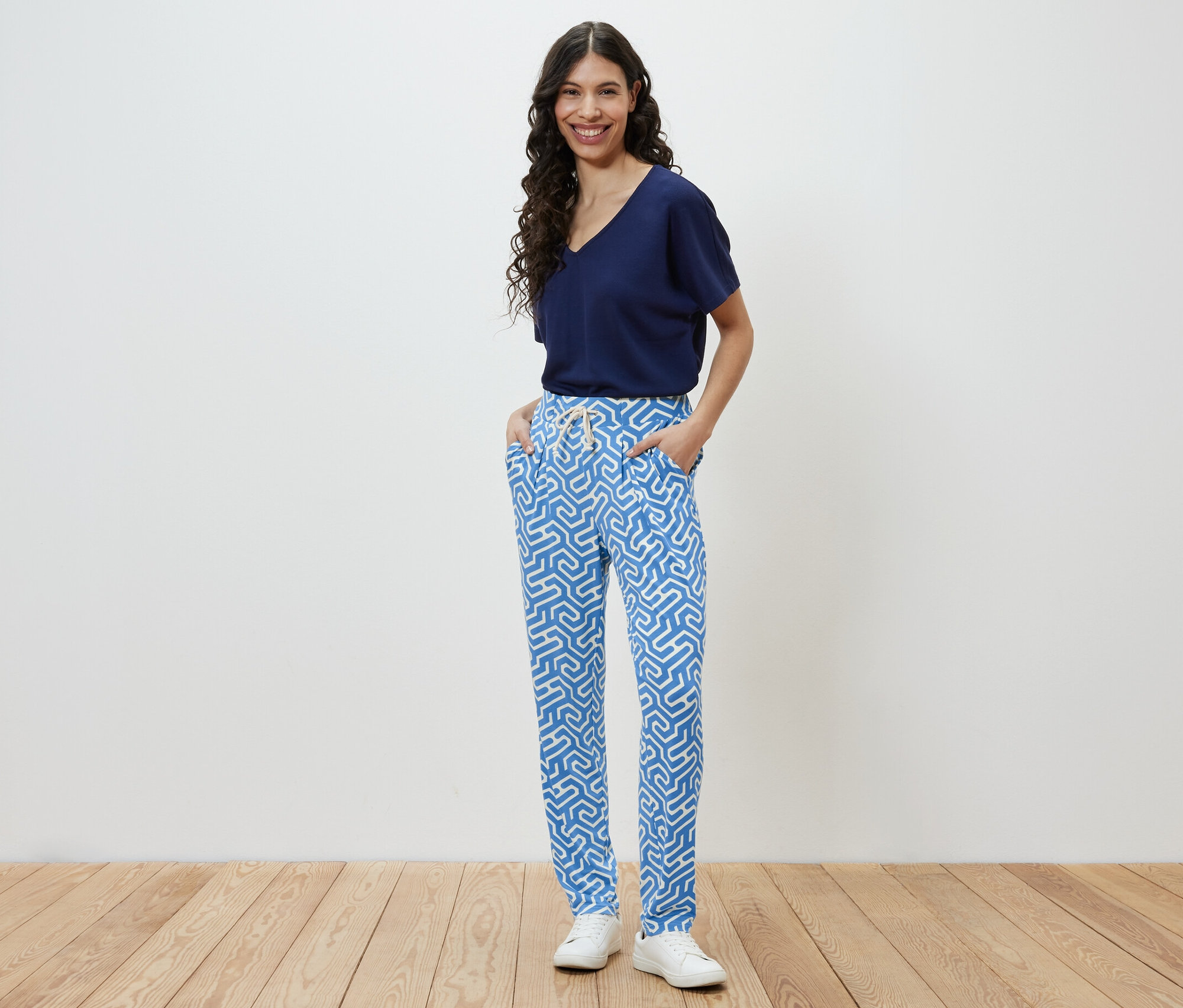 Femme posant en pantalon en jersey imprimé bleu.