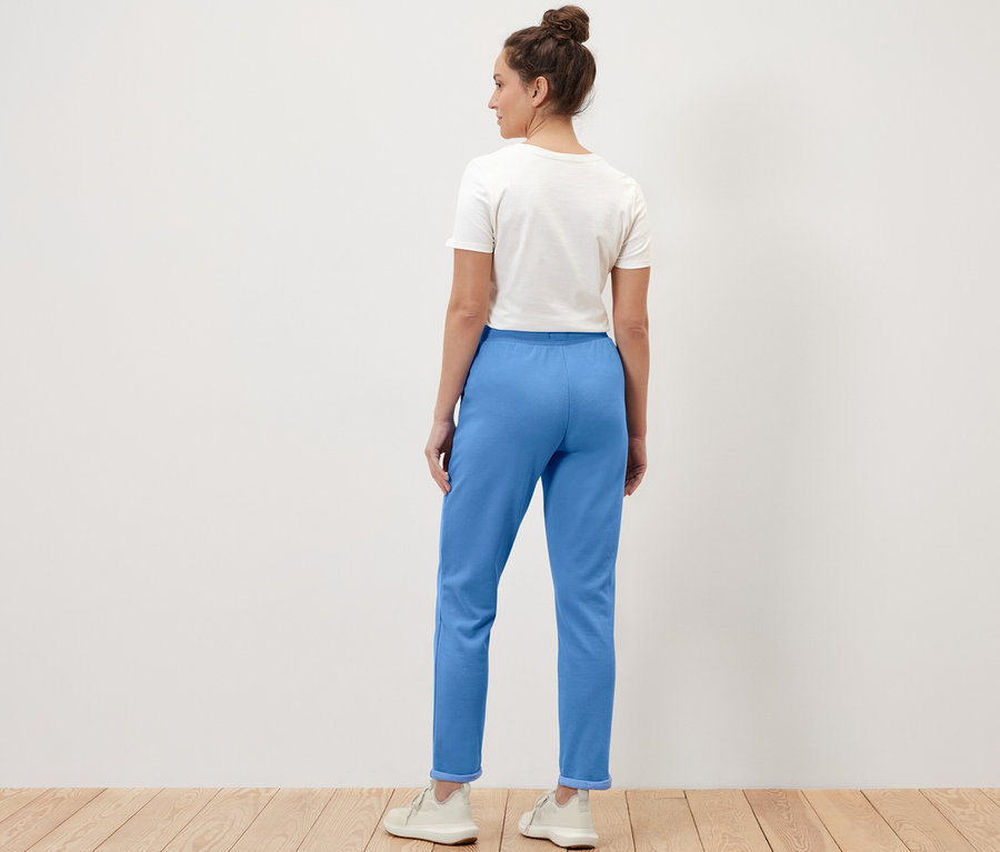 Femme posant en pantalon molletonné bleu foncé.