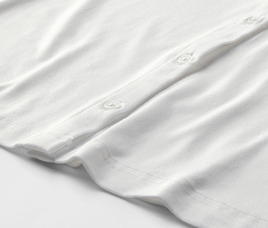Détail d'une blouse blanche avec patte de boutonnage.