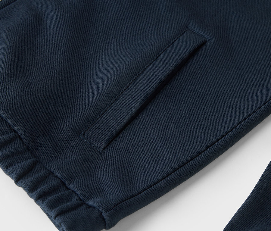 Gros plan sur un sweat-shirt bleu marine zippé avec une poche.