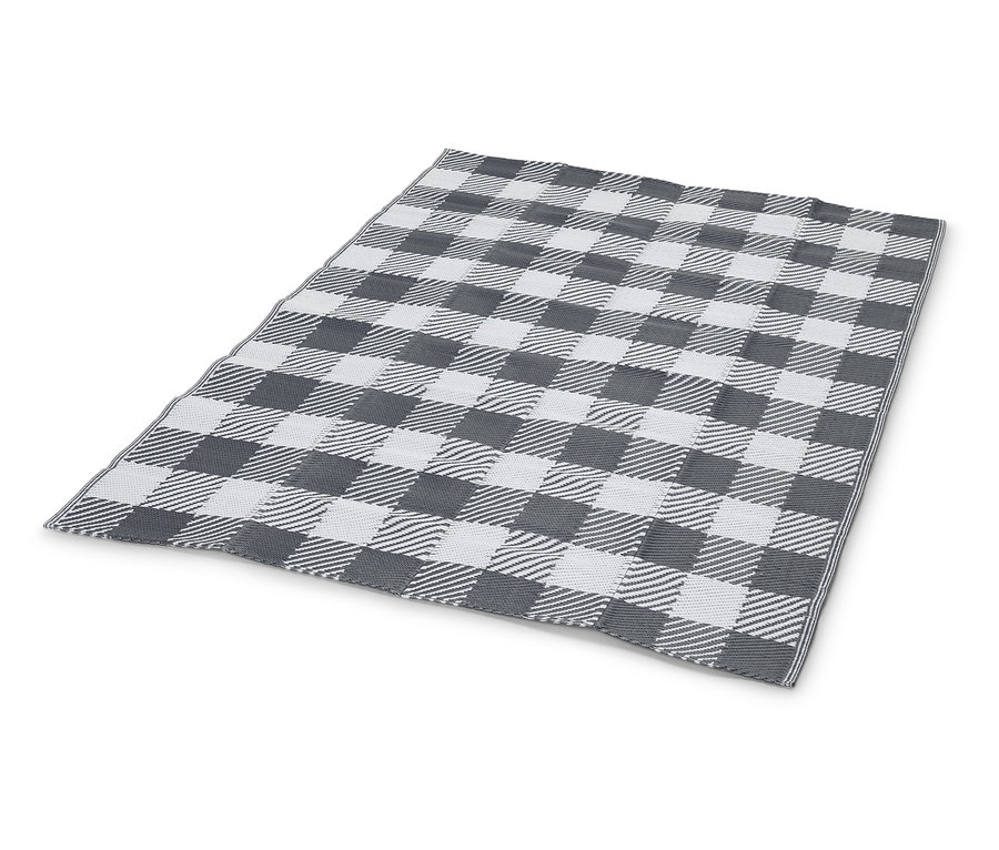 Une couverture à carreaux gris et blancs est posée sur un fond blanc.