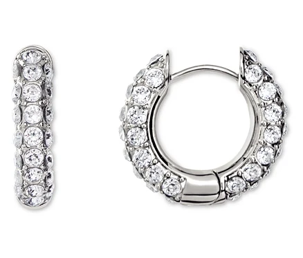 Gros plan de deux boucles d'oreilles créoles argentées serties de strass blancs.