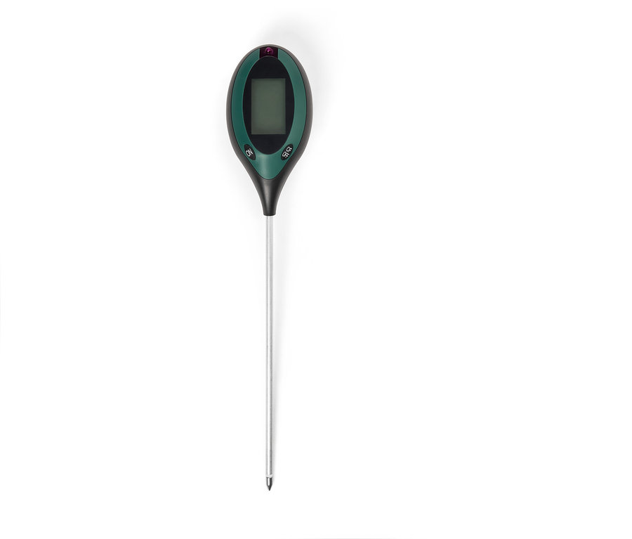 Un testeur de sol vert avec un écran LCD et une longue sonde argentée est posé sur un fond blanc.
