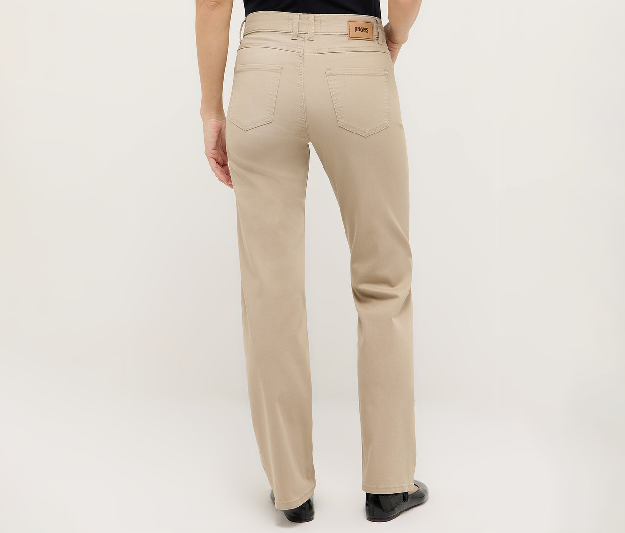 Vue arrière d'une femme portant un pantalon beige et des chaussures noires.