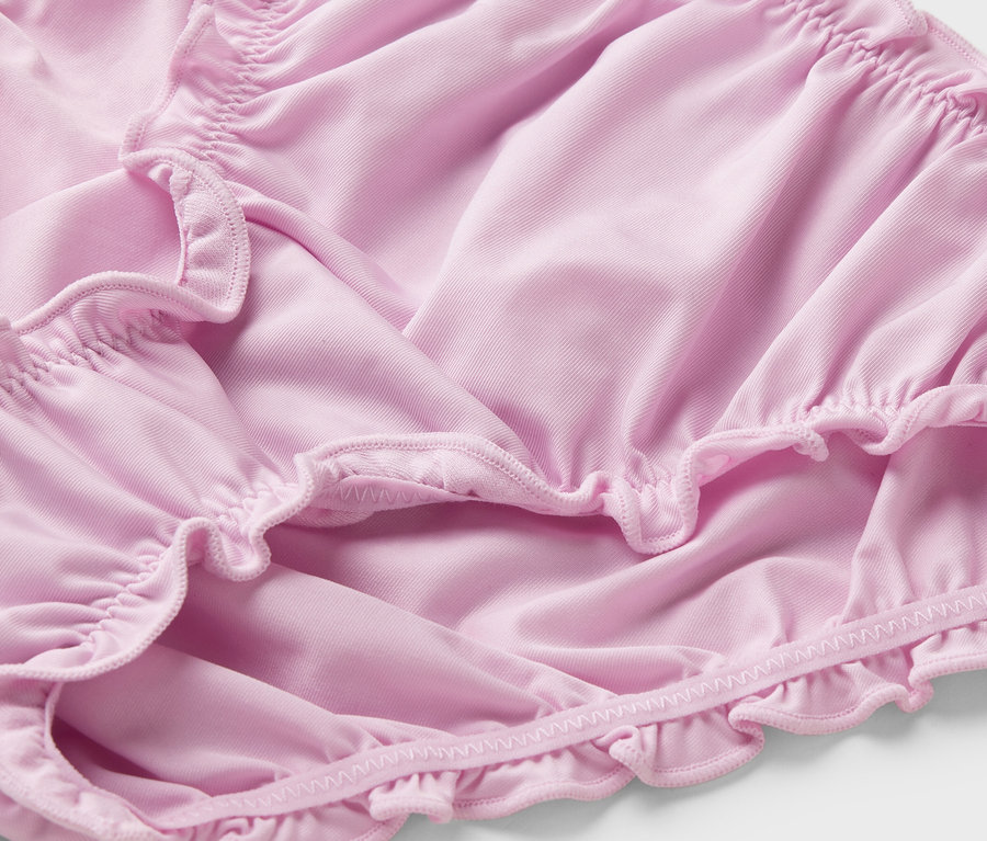 Gros plan d'une culotte rose avec des volants.