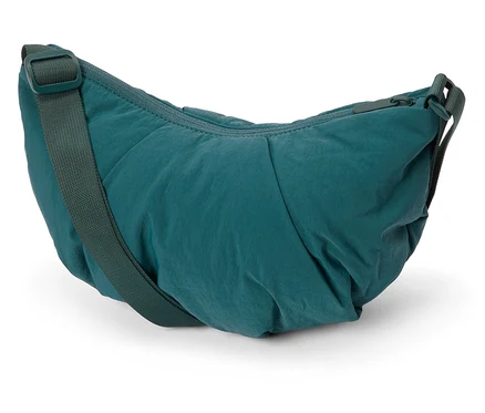 Gros plan d'un sac à bandoulière en nylon vert sur fond blanc.