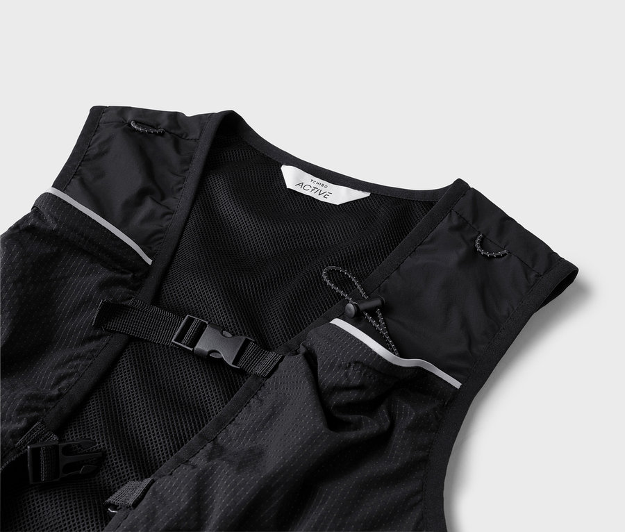 Gros plan d'un gilet de course noir avec des détails réfléchissants et des boucles.
