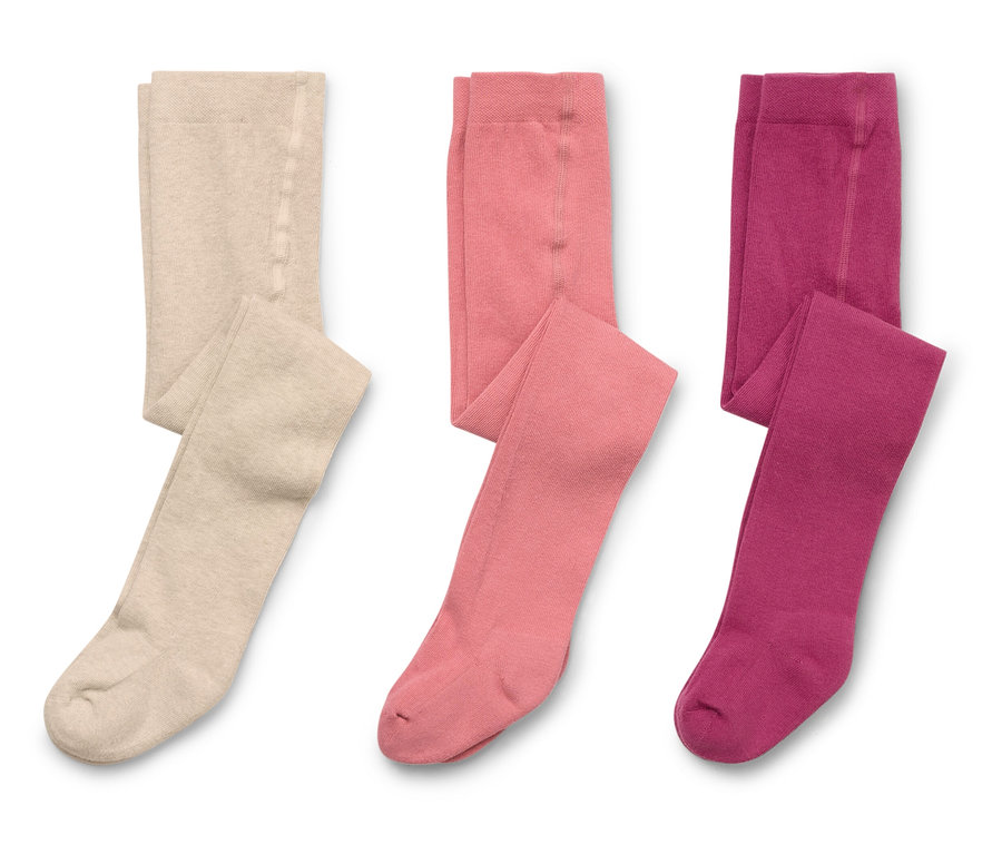 Trois collants pliés beige, rose et violet sont posés sur un fond blanc.