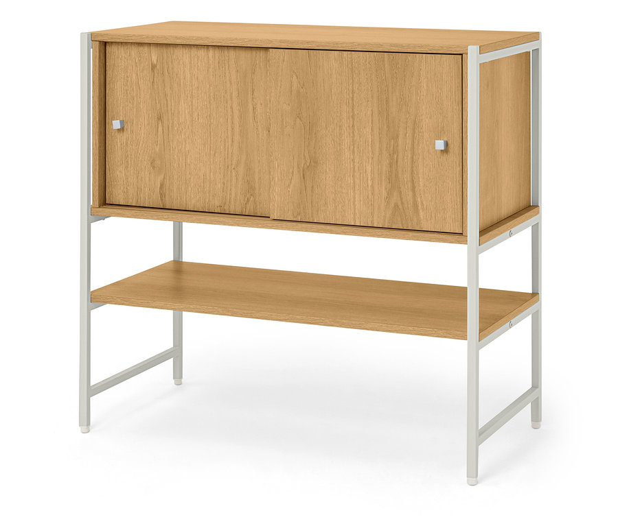 Une armoire en bois avec des portes coulissantes et une étagère repose sur un cadre en métal blanc.