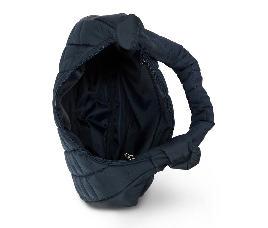 Gros plan d'un sac à main ouvert, matelassé et bleu marine avec fermeture éclair et poignée sur fond blanc.