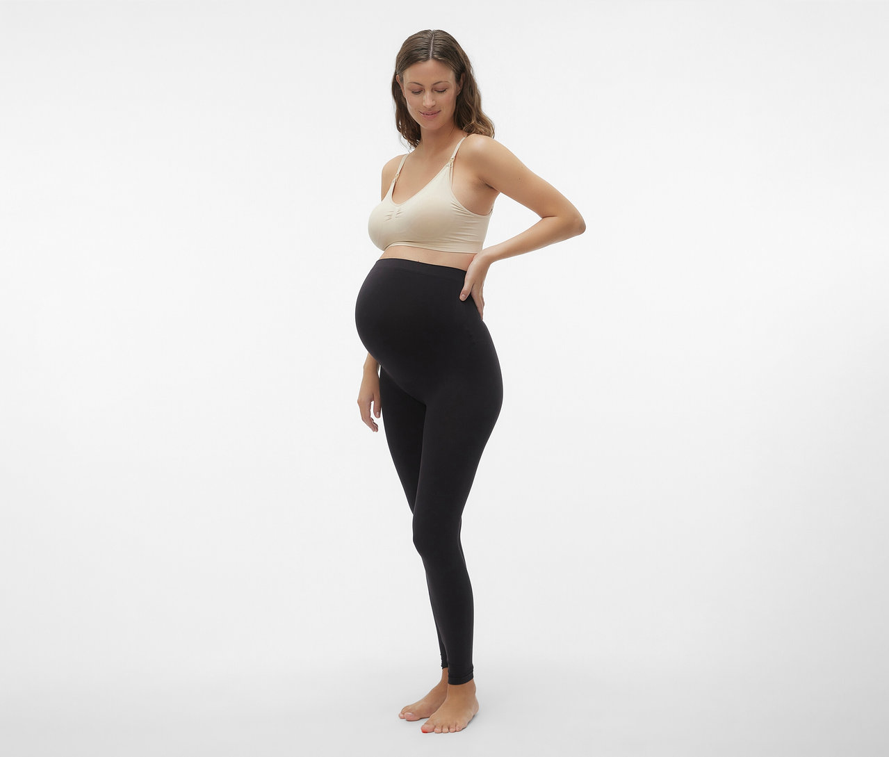 Femme enceinte en legging noir posant avec une MAMALICIOUS MLILJA FEED ME BRA 2-P NOOS beige.