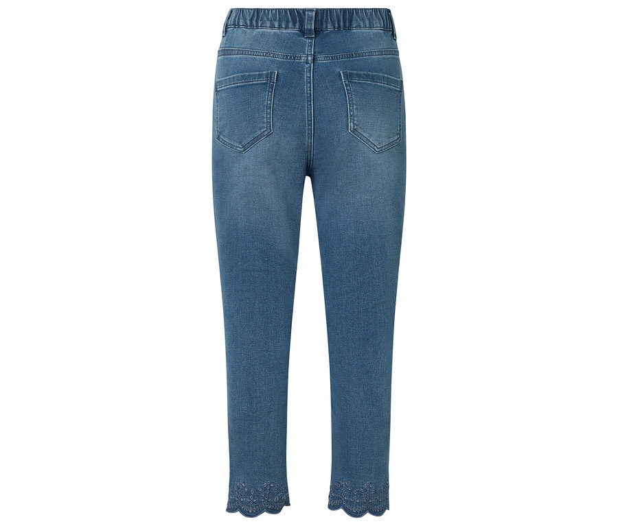 Gros plan sur l'arrière d'un jean bleu avec une taille élastique et de la dentelle décorative en bas.