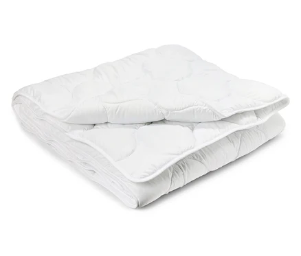 Une couette lavable à haute température de taille standard pliée sur un fond blanc.