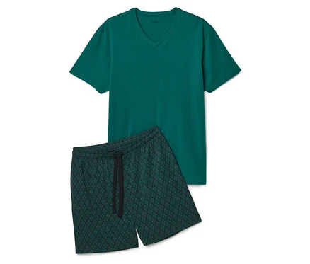 Un t-shirt vert et un short vert à motif géométrique sont posés sur un fond blanc.