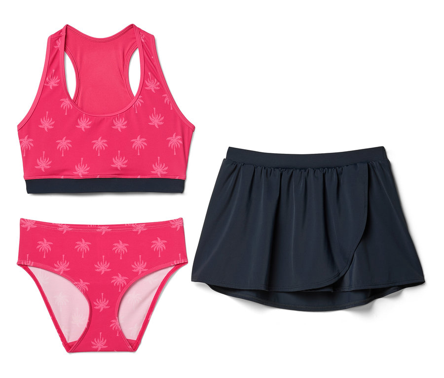 Haut de bikini rose et culotte de bikini à motif de palmiers à côté d'une jupe bleu marine.