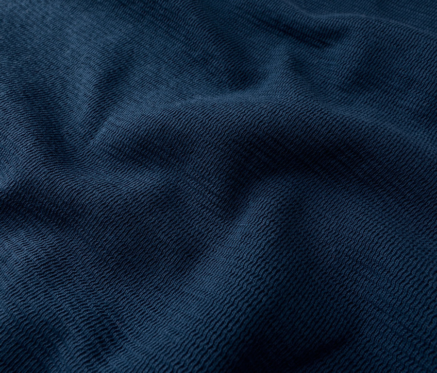 Gros plan d'un tissu bleu foncé avec une texture tissée et des plis.