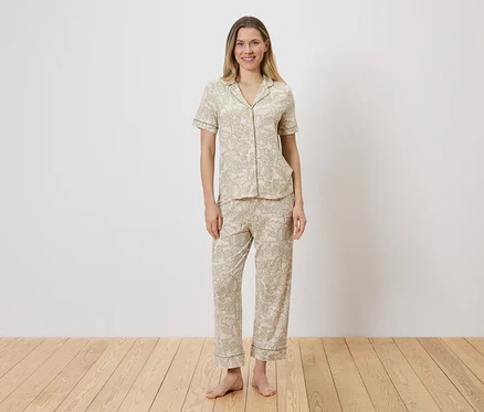 Femme portant un ensemble de pyjama clair à motifs, composé d'un haut boutonné et d'un pantalon.
