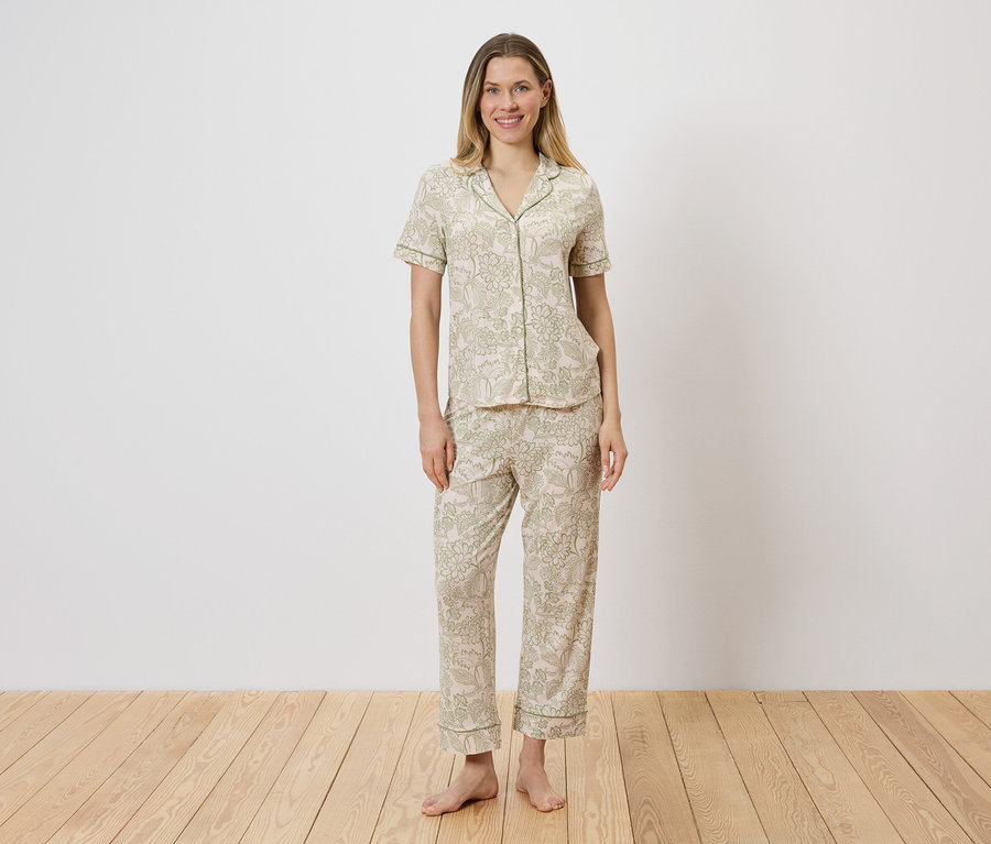 Femme portant un ensemble de pyjama clair à motifs, composé d'un haut boutonné et d'un pantalon.
