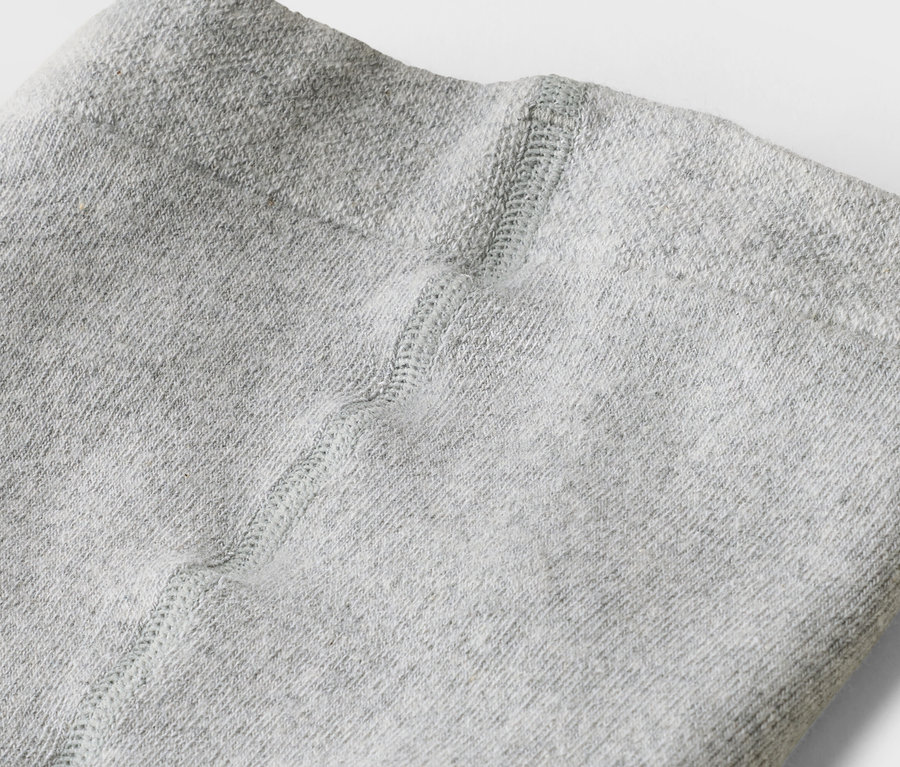 Gros plan sur un legging gris clair avec une couture au milieu.