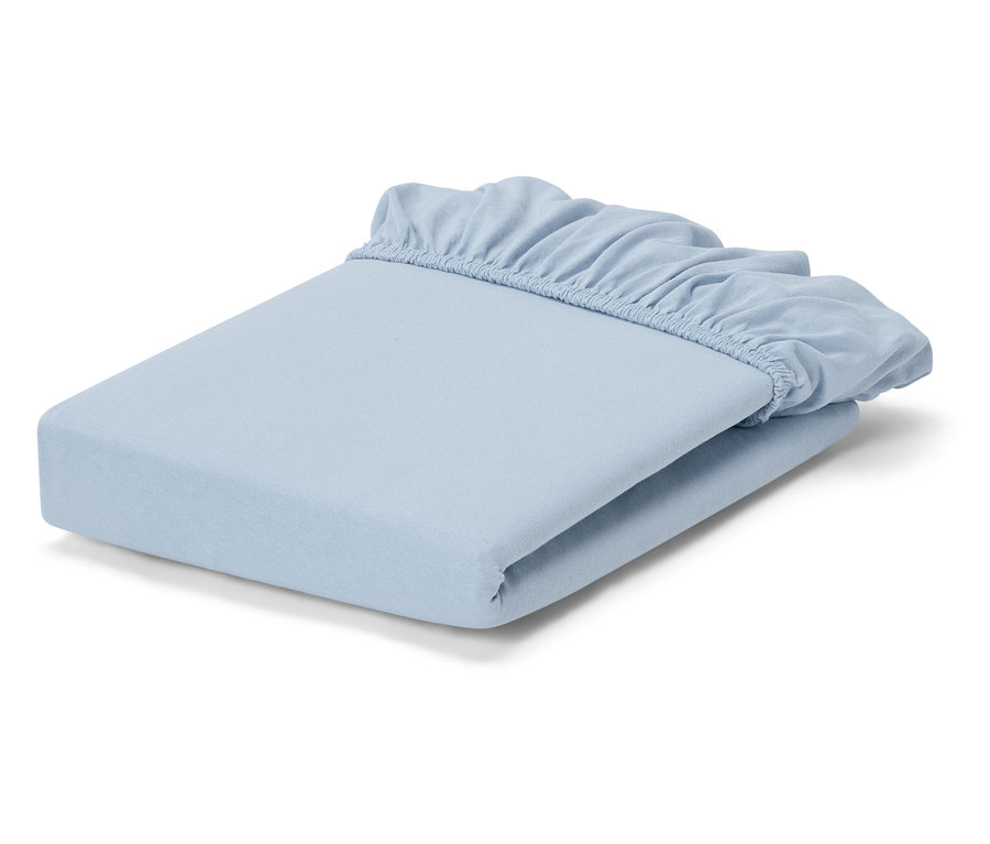 Un drap-housse bleu clair plié repose sur un fond blanc.