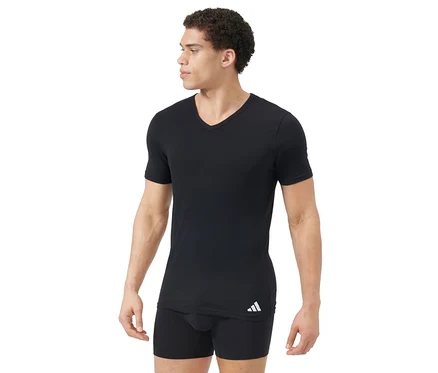 Homme portant un t-shirt noir à col en V et un boxer noir. Le t-shirt a un logo blanc en bas à gauche. L'homme regarde vers la droite.